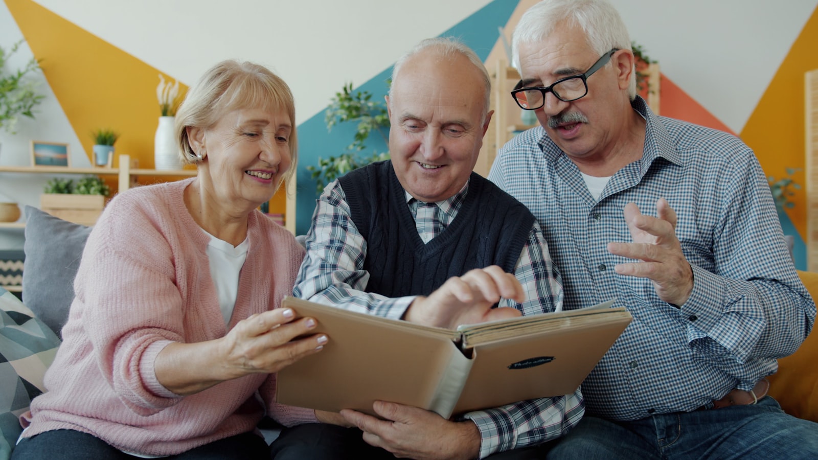 Trois résidents seniors partagent un moment complice autour d'un album